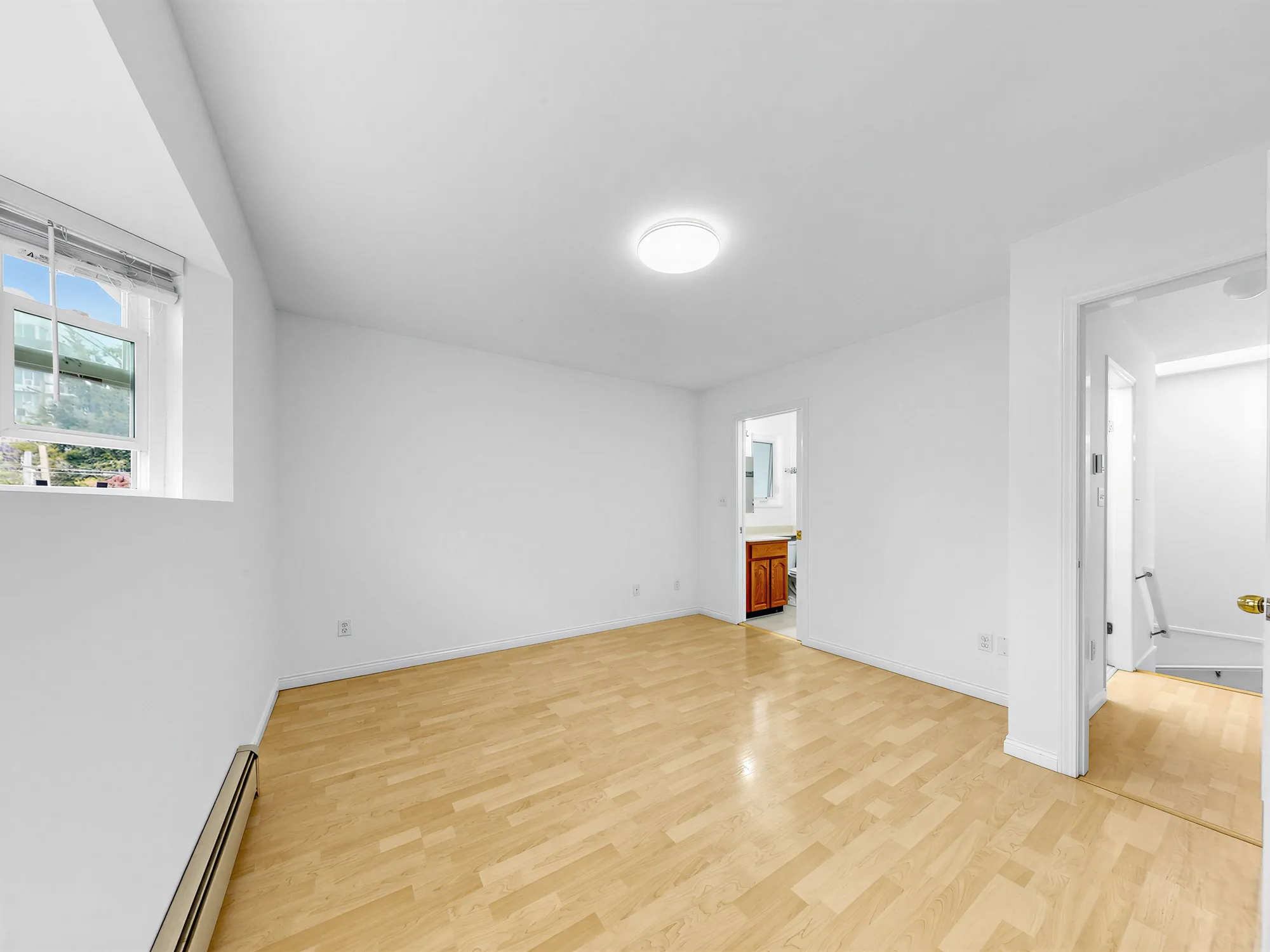 A room with a window on the left and a doorway on the right