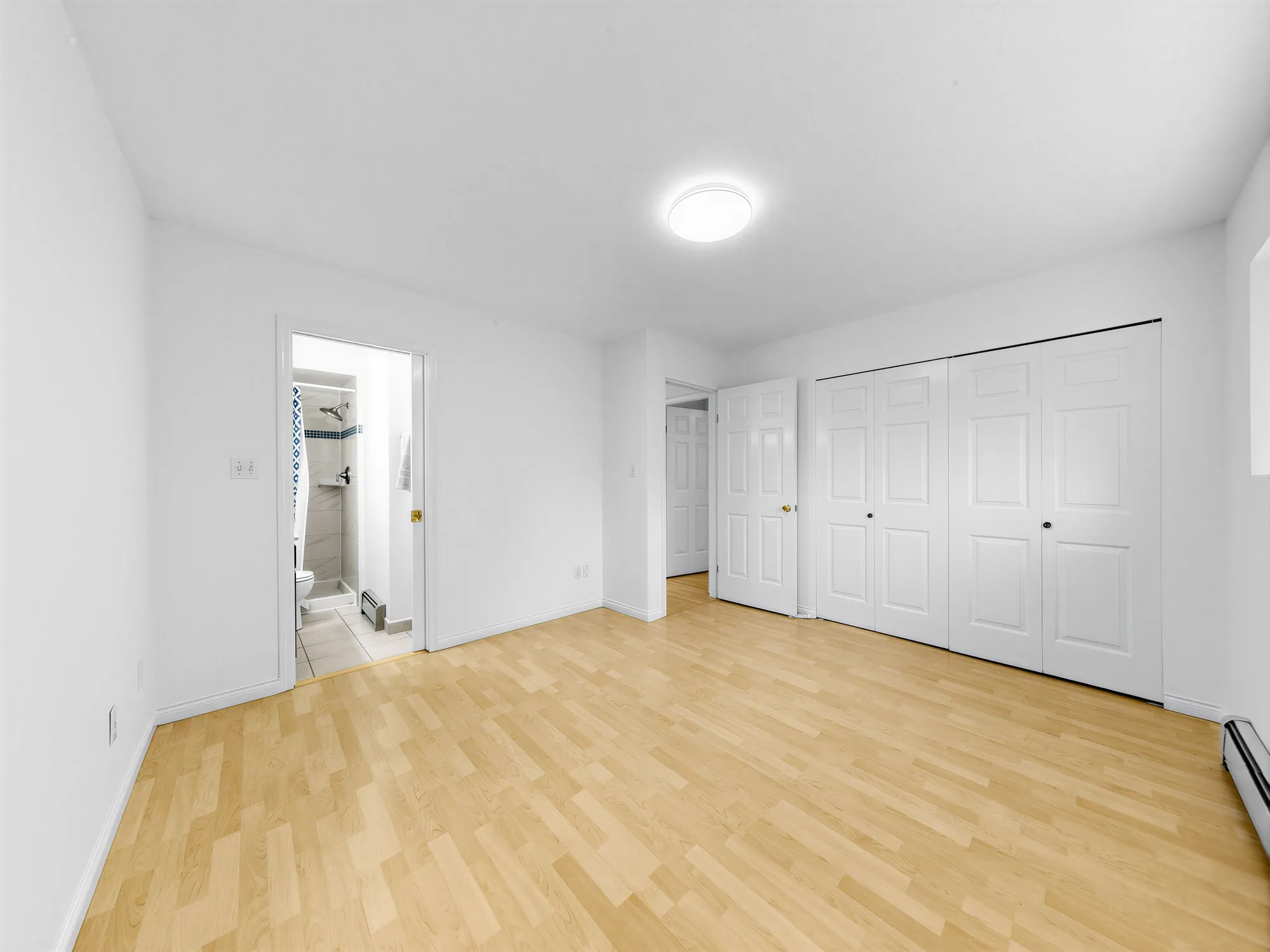 A room with a doorway through to a bathroom and a closet on the right