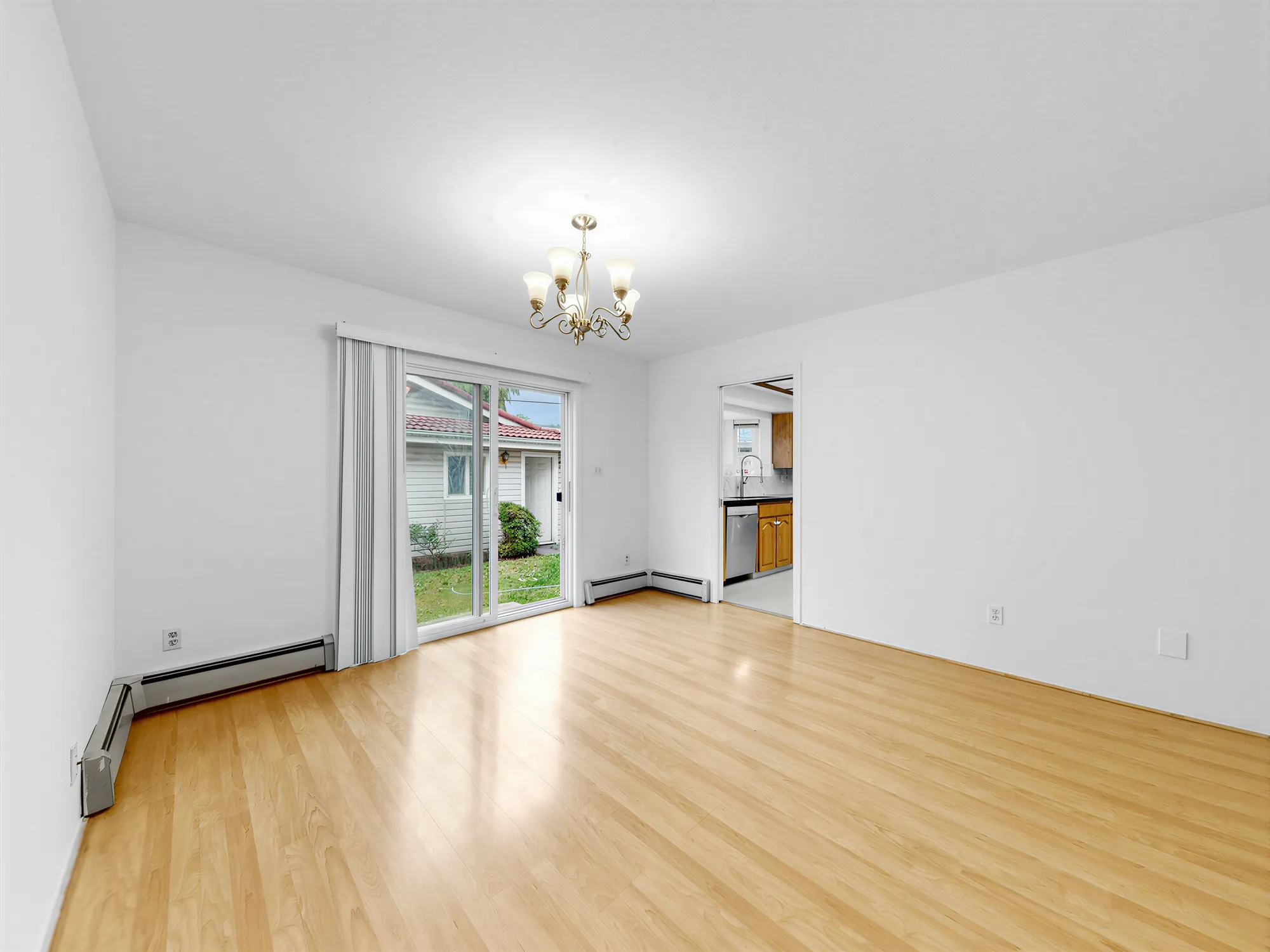 The dining room with a chandelier and a sliding door to the garden