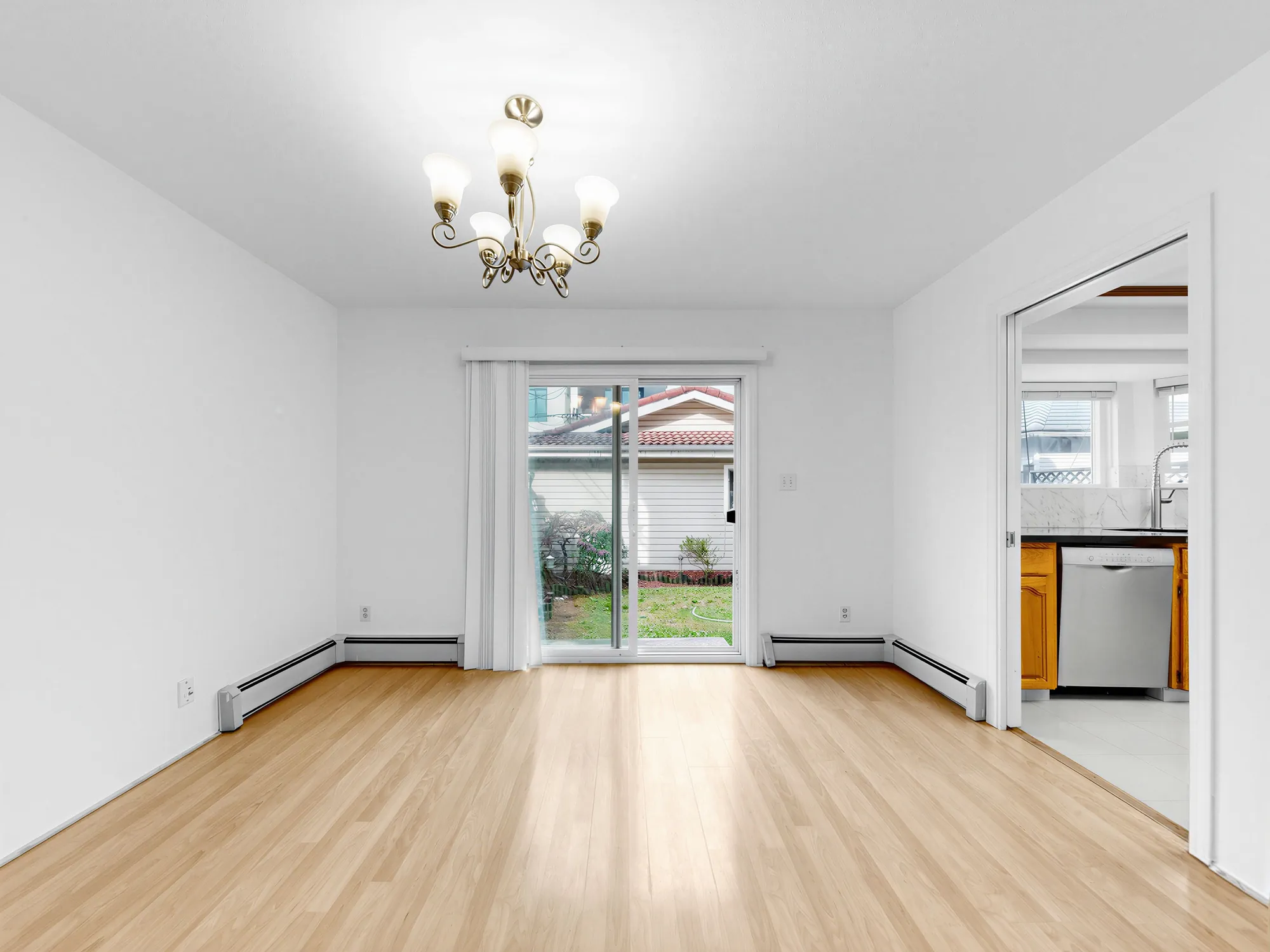The dining room from the opposite corner, kitchen opening on the right