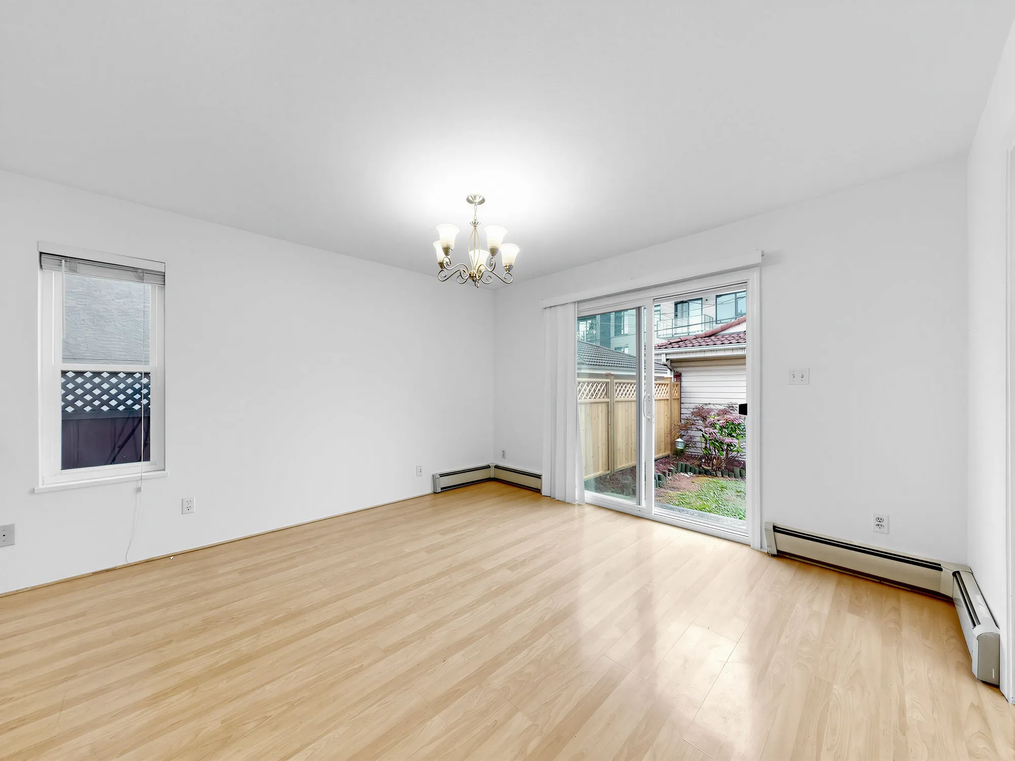 The dining room with a window on one side and the garden door on the other