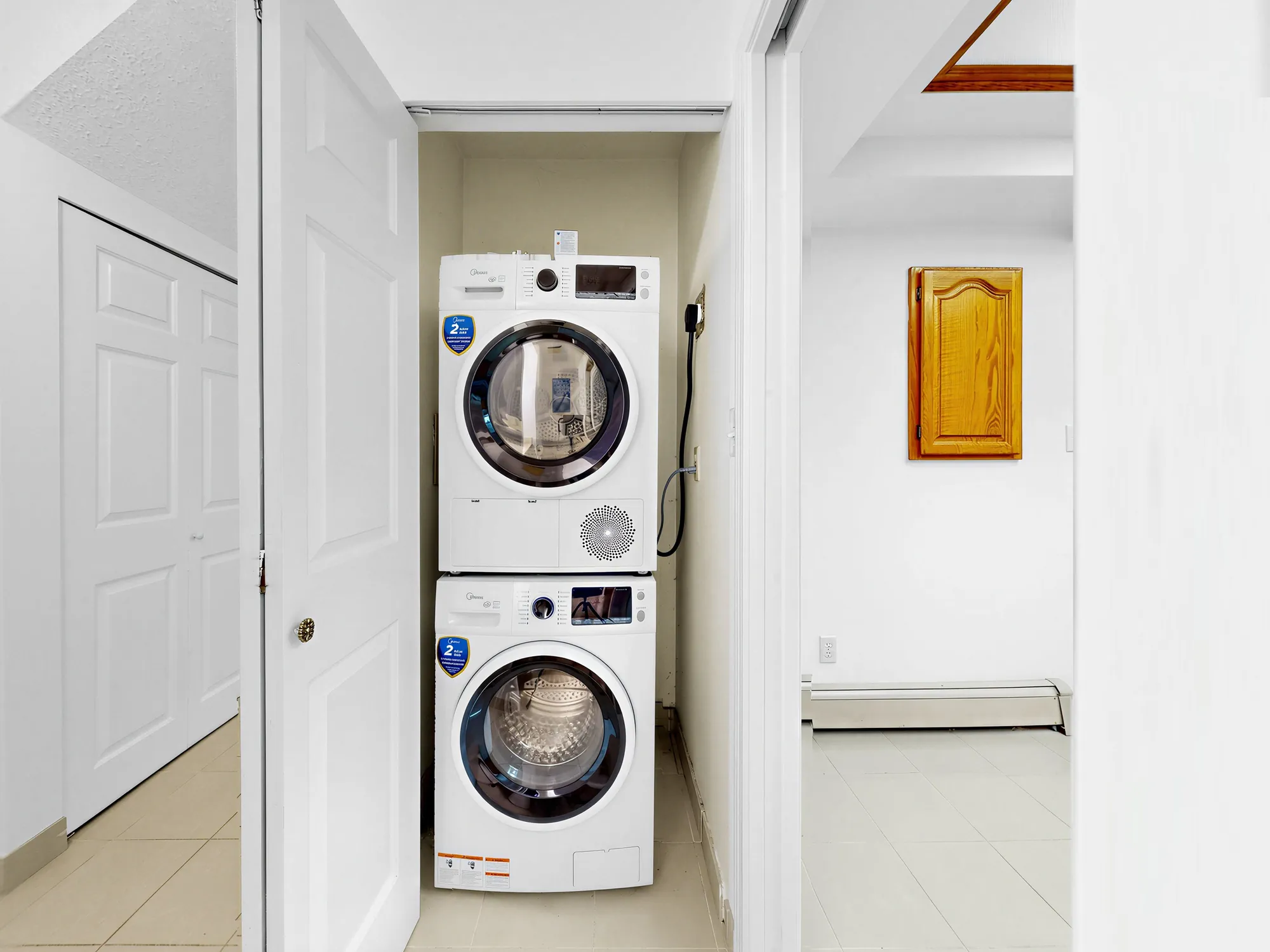 A stacked washer and dryer in a closet off the hall