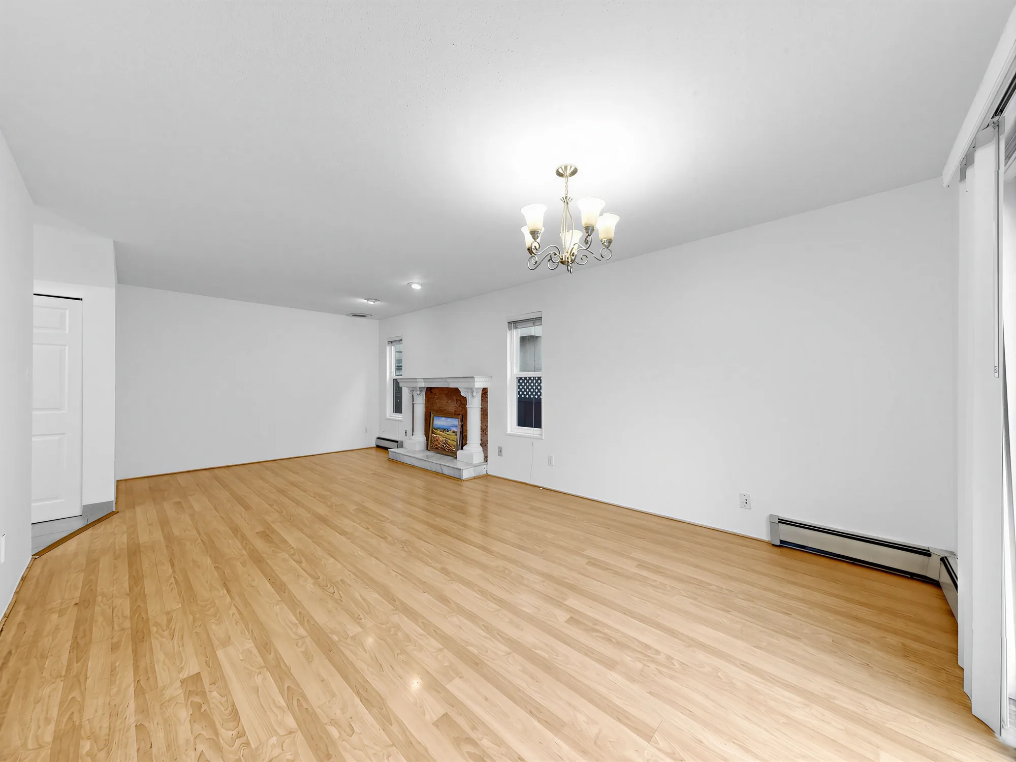 The living room under a chandelier, mantel to the left